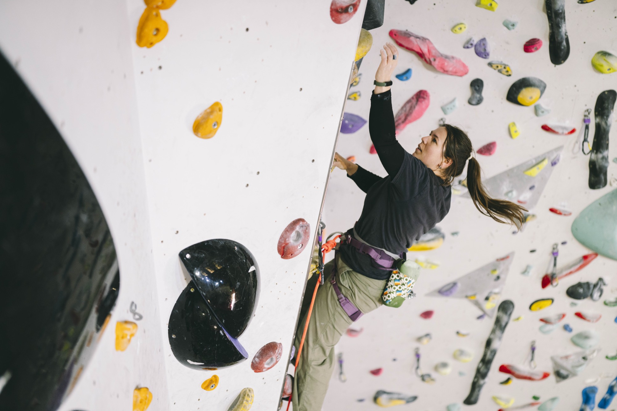 Climber committing to a move on an indoor wall